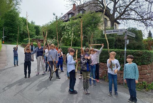 Kinder halten ihre bearbeiteten Holzstöcke in die Luft
