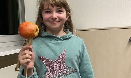 Mädchen mit Apfel am Spieß in der Hand