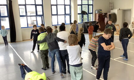 Einige Kinder stehen im Raum und stellen das Gefühl Kummer mimisch und gestisch dar