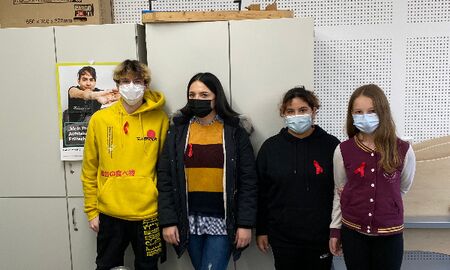 Auf dem Bild sieht man vier Schülerinnen und Schüler der SMV mit Informationsmaterial zum Welt-AIDS-Tag. Vier fleißige Helfer der SMV mit Infomaterial zum Welt-AIDS-Tag