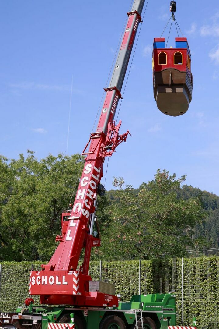 Das Playmobil-Schiff wird mit einem Kran über die Hecke gehoben (3).