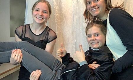 drei junge Damen machen Quatsch vor einer Fotowand