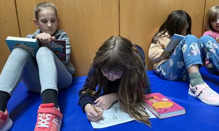 Kinder lesen auf einer Matte Bücher