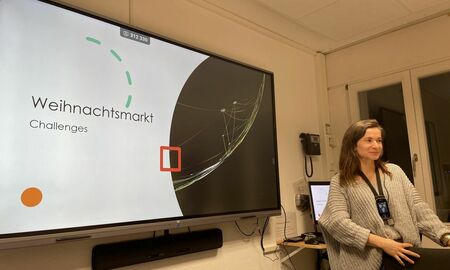 Eine Lehrerin präsentiert auf dem Interaktiven Panel die Weihnachtschallenges