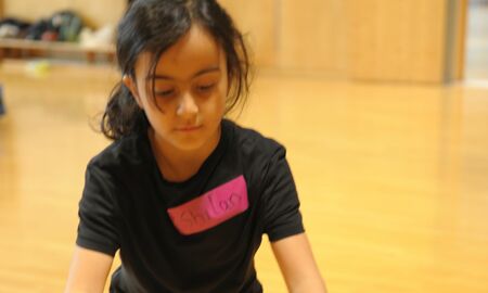 ein Kind trainiert mit Stäben