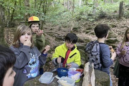Kinder essen im Wald