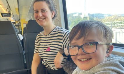 Eine Lehrerin und ein Schüler sitzen in der S-Bahn