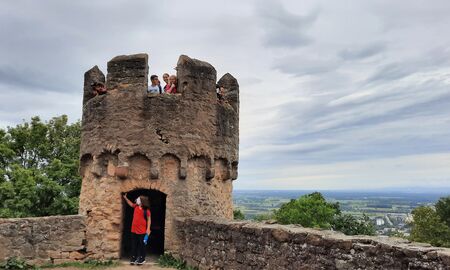 Auf einem niedrigen Burgturm stehen oben mehrere Kinder und schauen herunter oder in die Ferne. Unten in der Öffnung zum Turmaufgang steht ein Junge.
