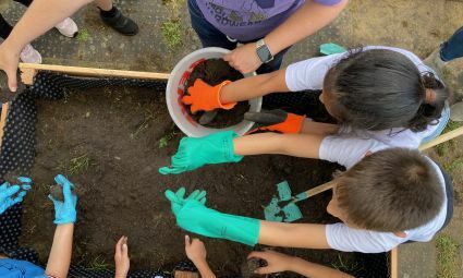 Kinder zerkrümeln Erde im Hochbeet