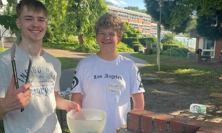 Zwei Jungs grillen Würstchen