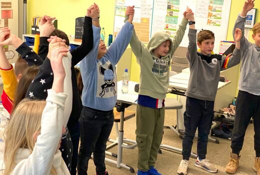 Kinder strecken die Arme aus und singen