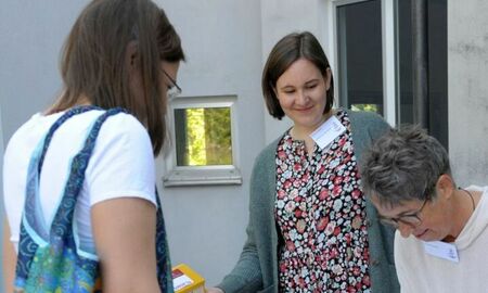 Drei Frauen stehen am Begrüßungsstand