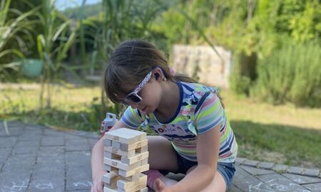 Ein kleines Mädchen baut einen Jenga Turm