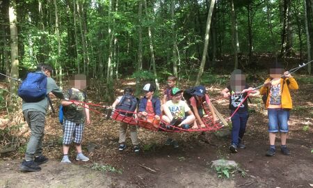 Acht Schüler die vom Lehrer auf einer Wippe schaukeln