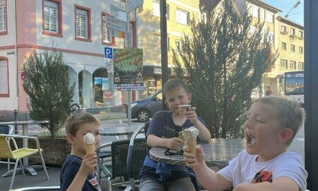Drei Jungen essen ein Eis in einem Eiscafe