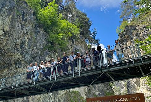 Alle Schülerinnen und Schüler  stehen auf einer Brücke die über den Gebirgsbach der Rosengartenschlucht führt.