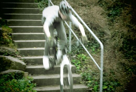 Ein Schüler fährt mit seinem Mountainbike sehr schnell eine Treppe herunter