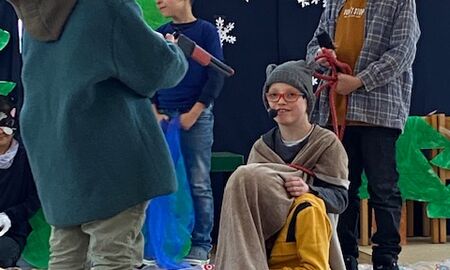 Das Musiktheaterstück "Peter und der Wolf". Man sieht Kinder verkleidet als Peter, den Wolf, einen Jäger, den Vogel und die Ente.