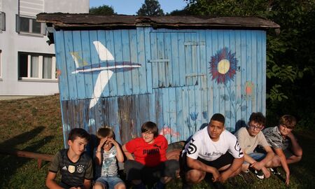 Schüler sitzen vor dem Bauwagen