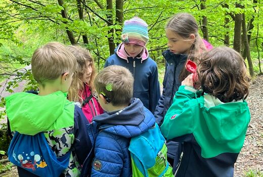 Kinder stecken die Köpfe zusammen und beratschlagen sich