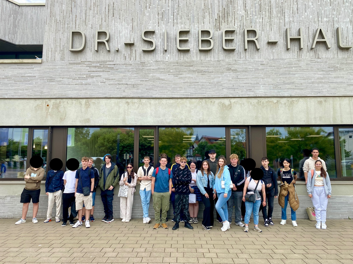 Schülerinnen und Schüler der Jahrgangsstufe 1 und 2 stehen vor der Dr.-Sieber-Halle in Sinsheim.