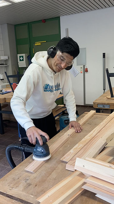 Ein Schüler poliert das Holz.