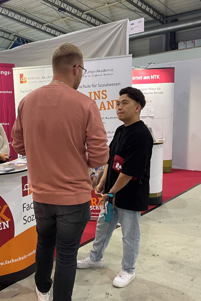 Hadi informiert sich an einem Stand der Fachschule für Sozialwesen.